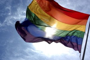 Bandiera Rainbow LGBT che sventola e sfondo cielo con il sole